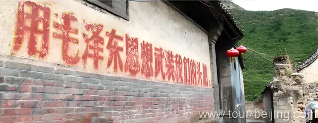Fading Mao's Slogan on the house wall