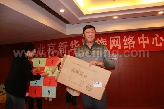 Mr. Xie gets a laptop desk (used on bed ) after he wins in a price guess game.