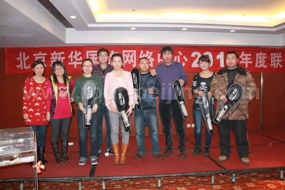 The fourth lottery prizes winners are posed on the stage with their prizes of badminton rackets.
