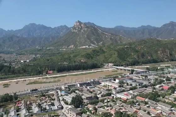 Atop a mound, we had a clear view of the Wohushan Great Wall on our east side and the Gubeikou Township in the valley .