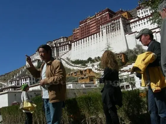 A Tibetan English speaking tour guide is introducing the history of Potala Palace.