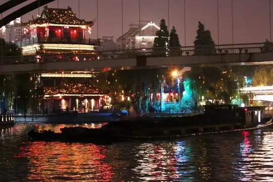 A barge is sailing under a bridge