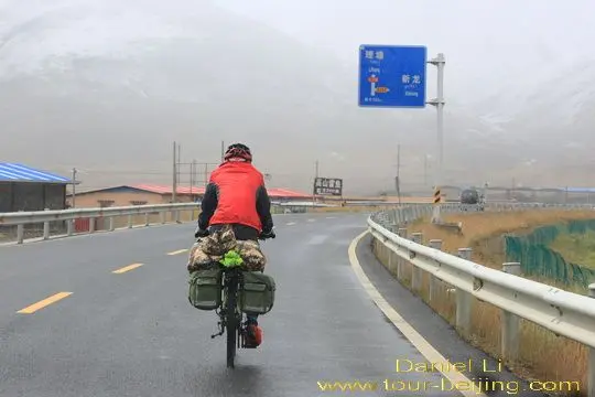 A cyclist is biking towards Litang Town