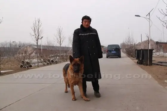 A farm security guard is excited at our early morning visit and insists in posing before our camera for a photo with his dog.