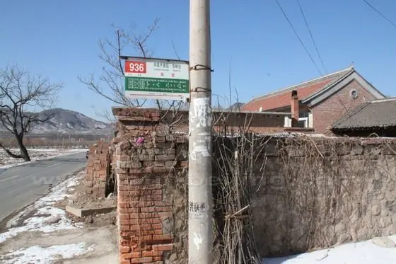 A sign of Bus No.936 Dong Gong Stop stuck to a telephone pole.