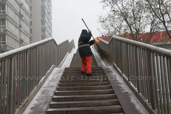 A snow clearing worker is clearing the snow from the flyover.