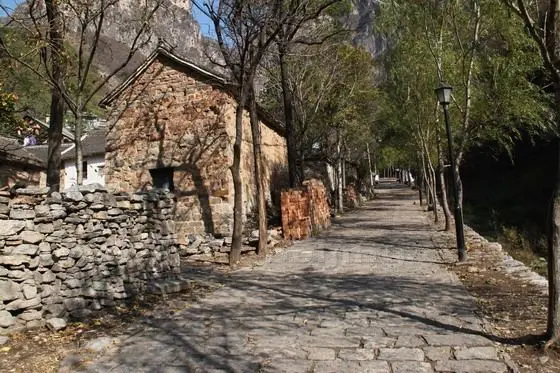 A stone paved road leading up to the back of the village