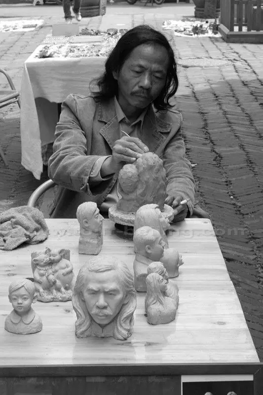 A stonemason is working on his products