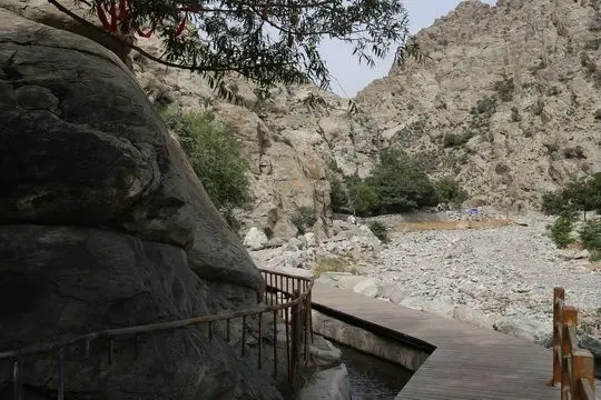 A wooden path winds along the edge of the valley