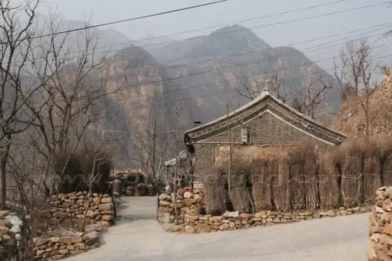 An old house with 2 or 3 rooms within a shabby stone wall, forming a simple courtyard.