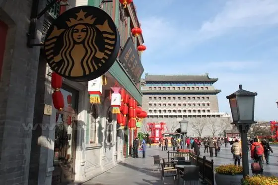 By the decorated archway is a starbucks with old design