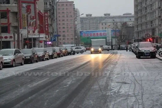 Cars are moving slowly on the newly fallen snow on the road