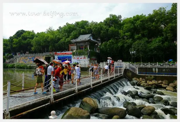 Crossing Taohua River along the stone bridge linking the two banks.