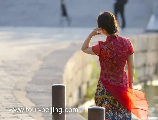 Snap a photo of a smartly dressed lady by the bridge.