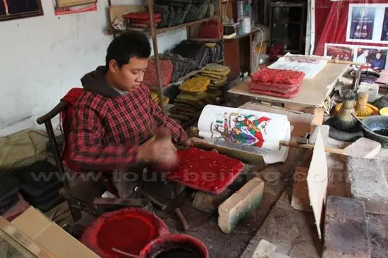 He is brushing the red color on the block
