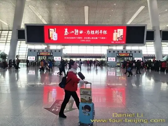 Looking for Departure Gate and Rolling Their Luggage