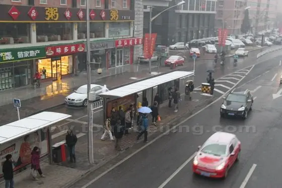 Many commuters are waiting for their buses at the bus station below the flyover.