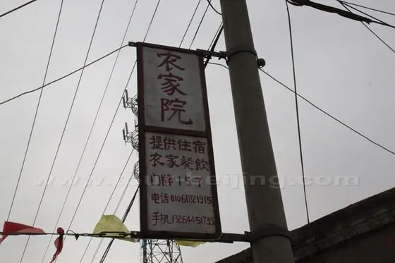 One household advertisement placard hanging on the pole promoting the rural tourism offering accommodation and dining.