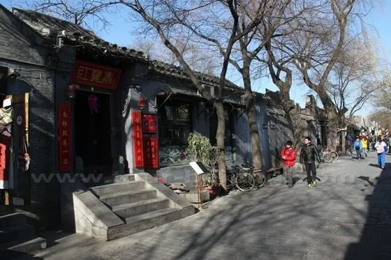 One storey grey building and brick paved road