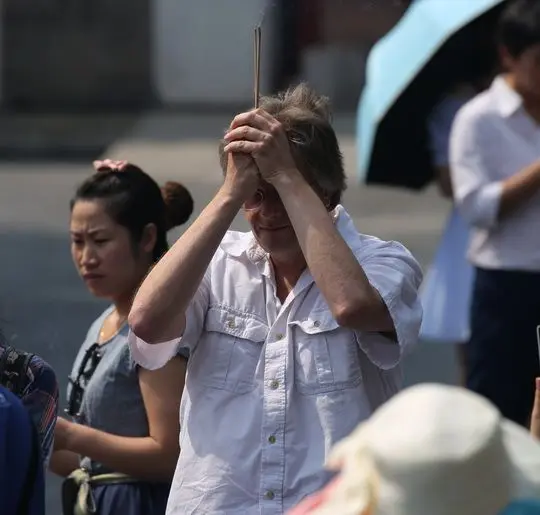 Raising joss sticks over the head and taking to the Buddha