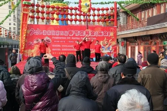 People are gathering around the stage enjoying the performance