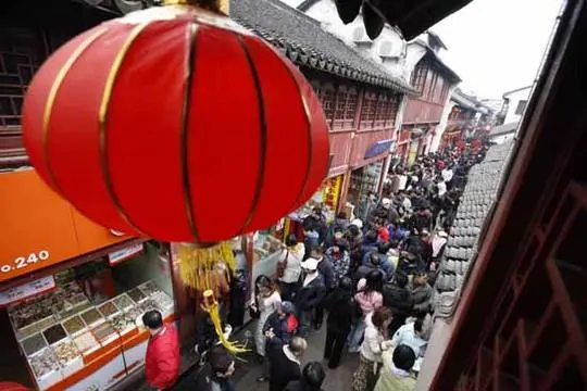 The narrow lane is packed with people.