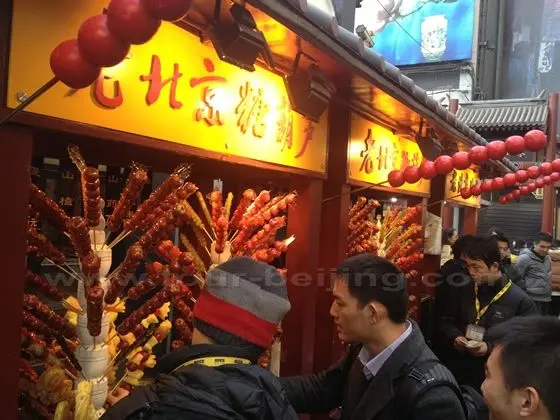 Skewered sugar-coated haws and more fruits sugar coated on sticks are sold alluring eaters in and out.
