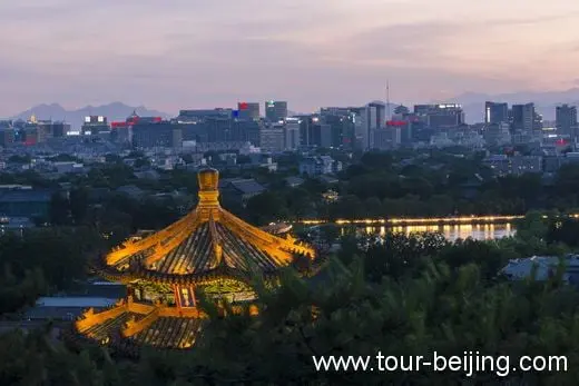 Looking at the southwest: An illuminated Pavilion and neon-lit Buildings in the distance.