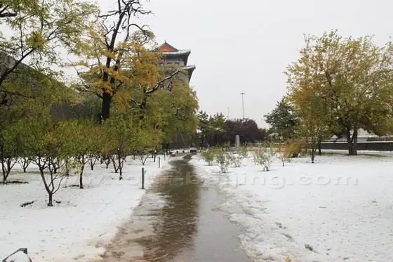 The Arrow Tower is hidden behind the atumn leaves with the early winter snow on the ground