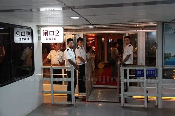 The boat staff persons are standing at the boarding gate welcoming us