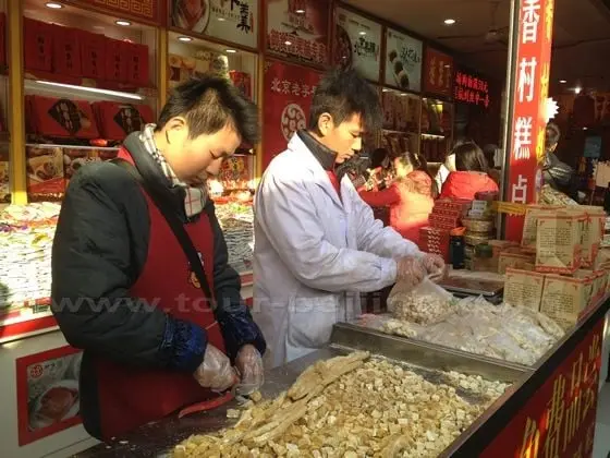 The cakes are cut into small square pieces for sale.