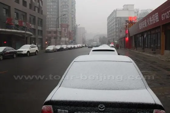 The cars parking on the roasides hold the snow