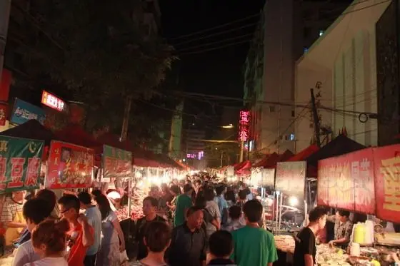 The diverse night stands fill up the narrow lane.