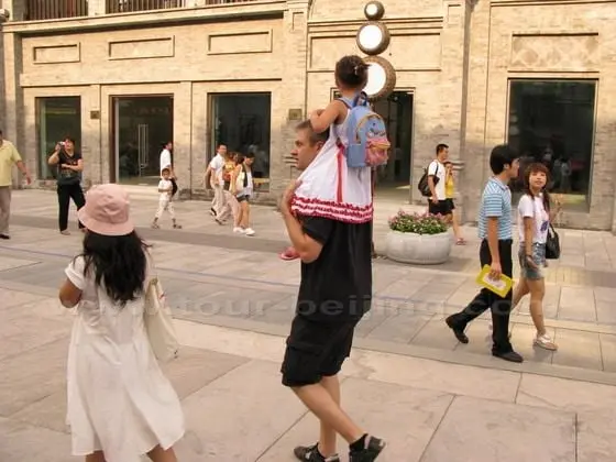 The father and daughter are ambling on the street.