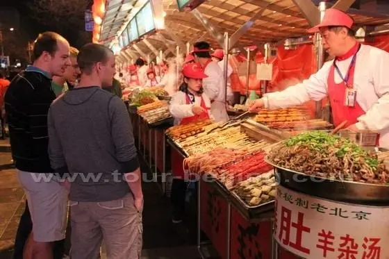 The foreign tourists are curious about the snake meat.