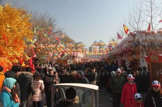 The road is packed with visitors and lined up with games stalls