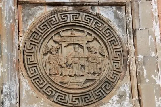 The stone-carved figures the front wall still guard the old courtyard