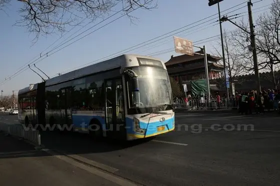 The trolley bus is passing by the north gate to Forbidden City