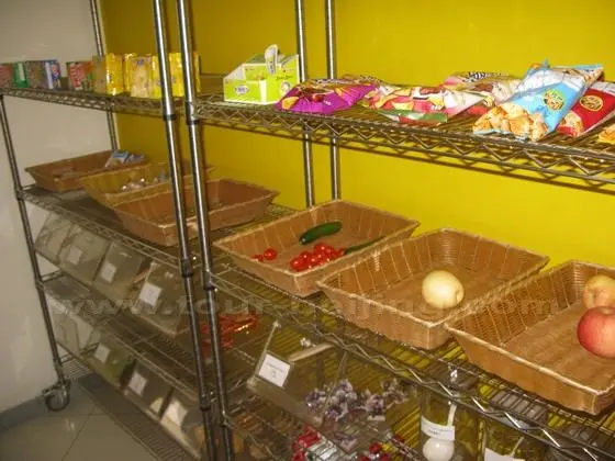 Various fruits, snacks are put on shelves.