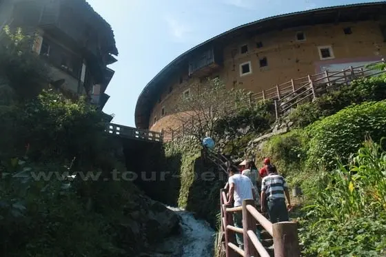 We are walking up to the earth building - Jiqing Tulou Building