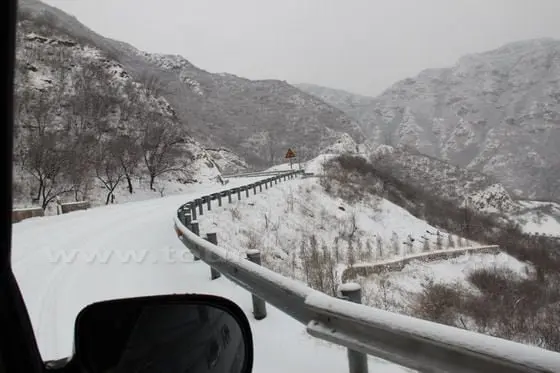 We drive along zigzag mountain road and pass two mountains before we reach Changyucheng Village