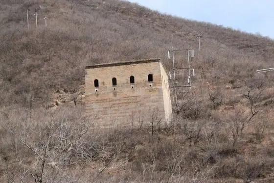 We see a watch tower on the hillside high above the deep valley. There used to be several guide towers of Great Wall.