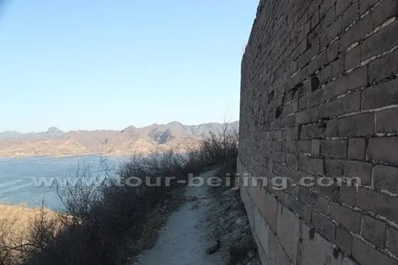 We tredge up the hill and walk along a trodden path by the wall.