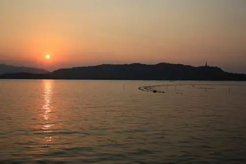 The red and orange colors of the sunset mirrored on the lake