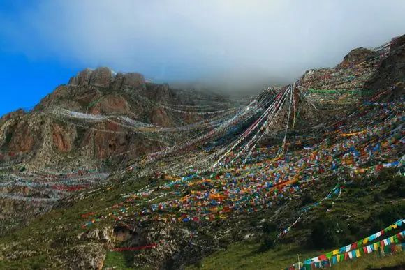 A mountain of five coloured prayer flags.