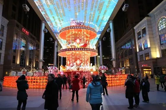 a large flower basket decorated with horse toys and illuminated red lanterns.