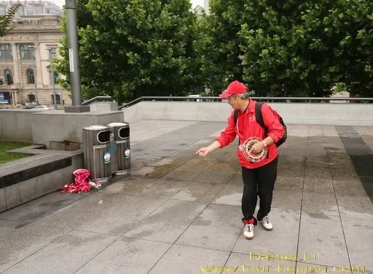 Placing his kite up on the ground.