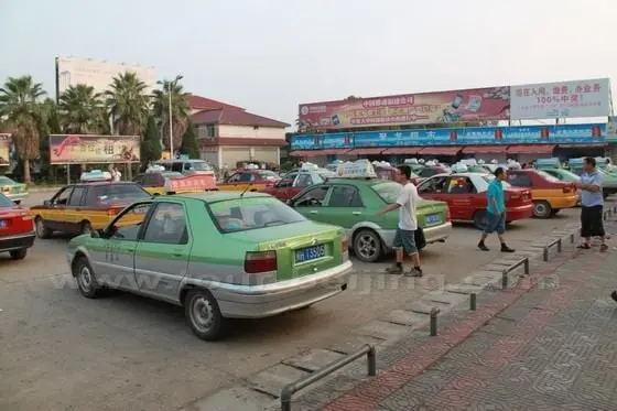 many taxis waiting on the square in front of main building of Wuyishan Railway Station
