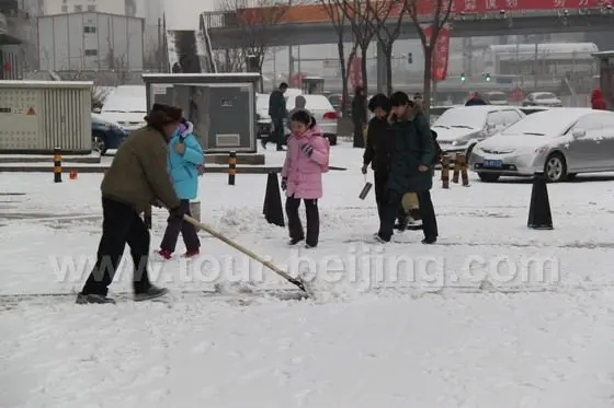 Shovelling the snow off the path.