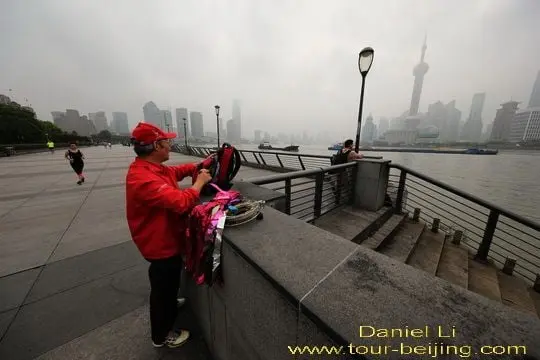 Mr. Zhao takes out his kite and the spool of strings.